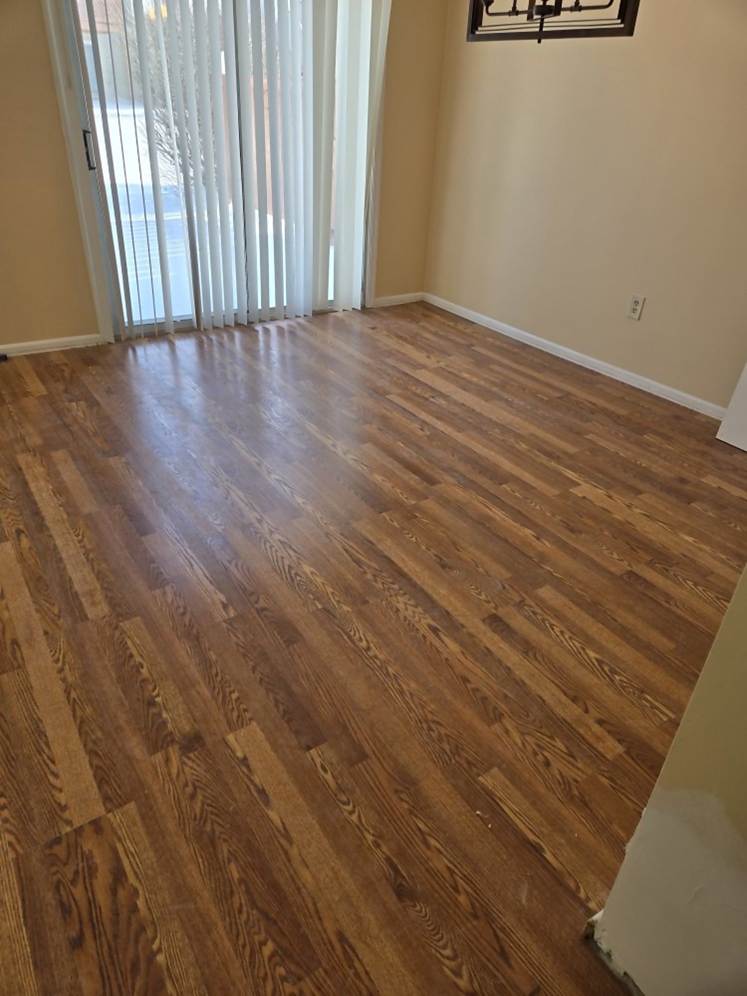 Refinished solid hardwood flooring in a sunlit living room
