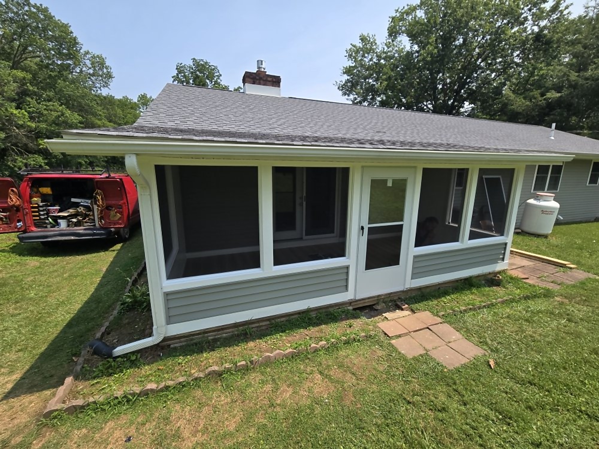 Completed Pro One sunroom addition with wide window wall on a ranch home