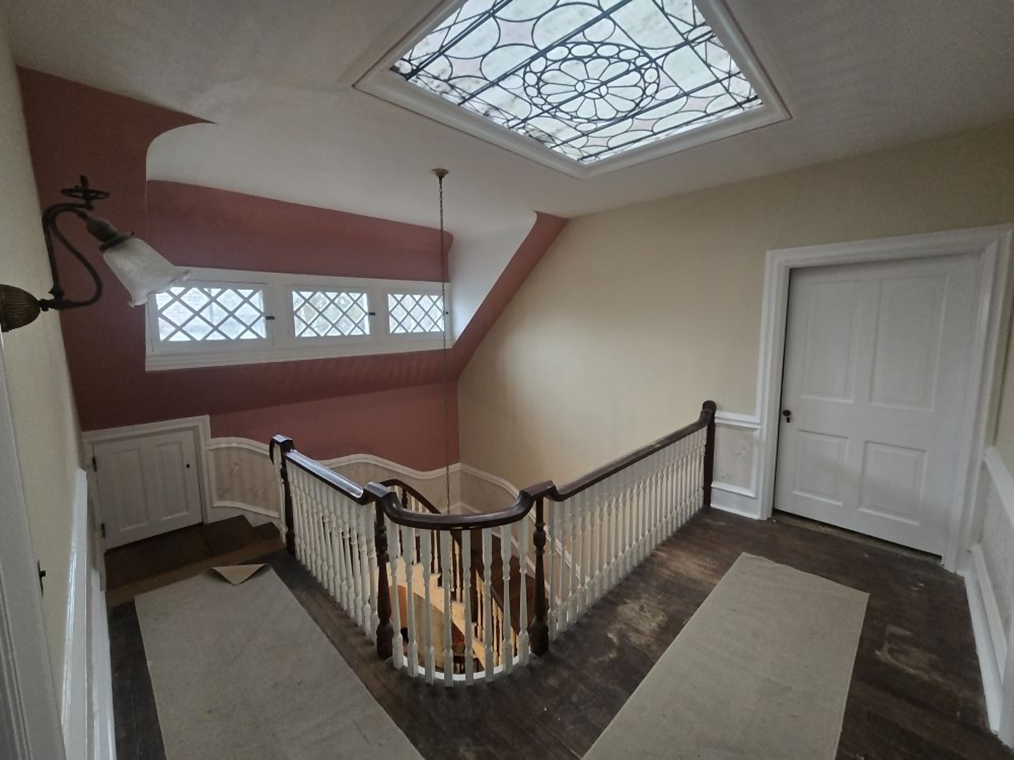 Finished stair hall with deep red accent wall painted by Pro One