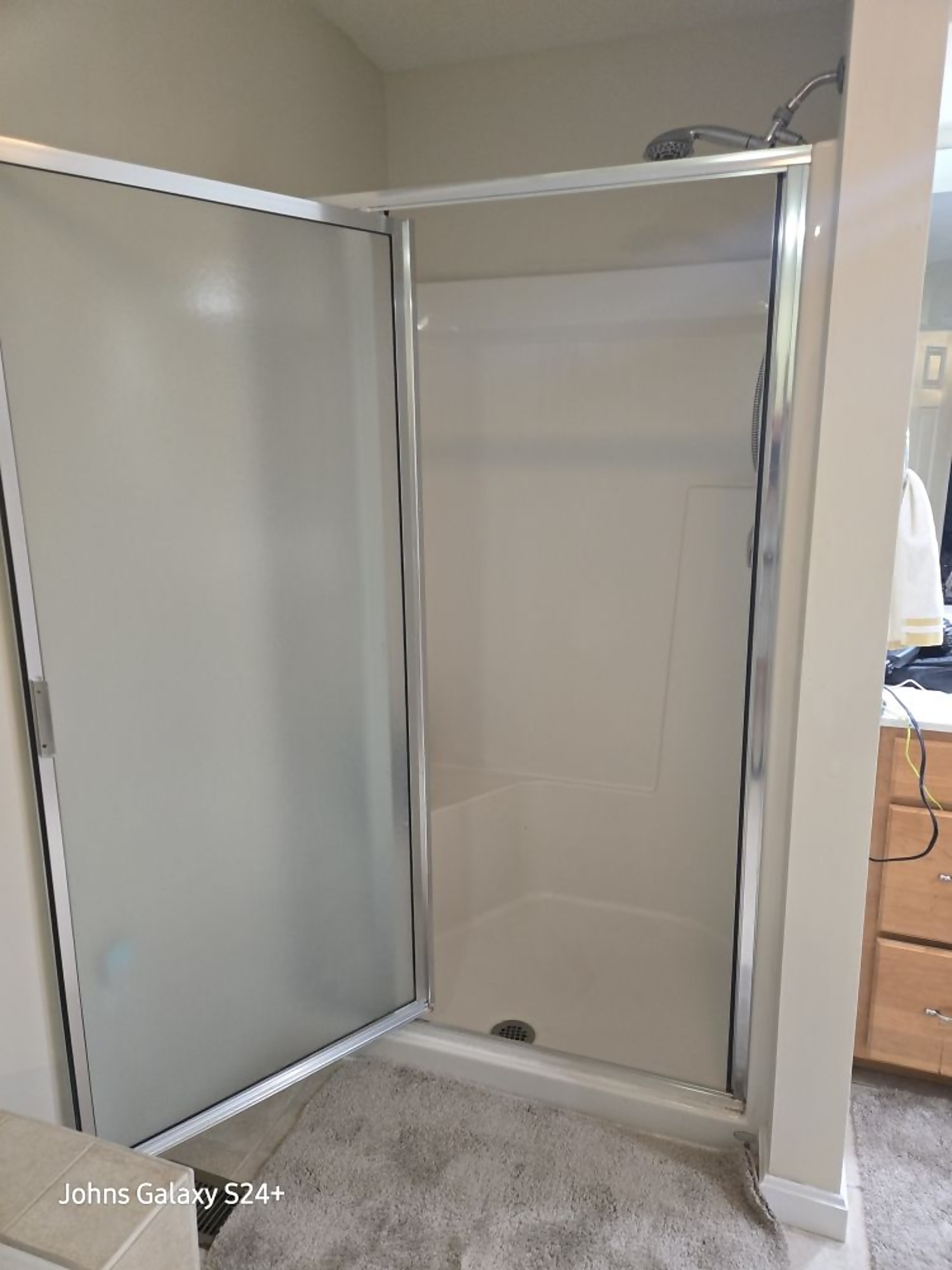 Newly installed shower enclosure with framed glass door in a bathroom