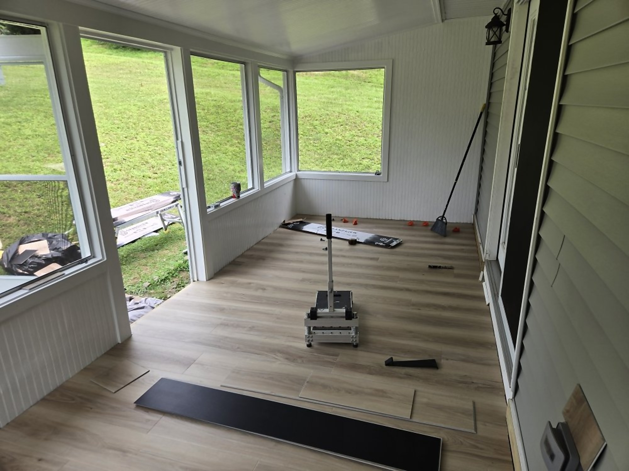 Interior of a sunroom addition with new plank flooring being installed